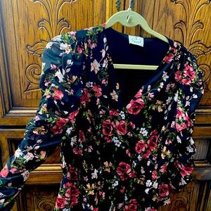 Peplum, cinched puff-sleeved floral blouse.